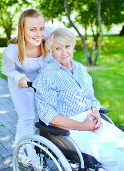 senior woman sitting on wheelchair with caregiver